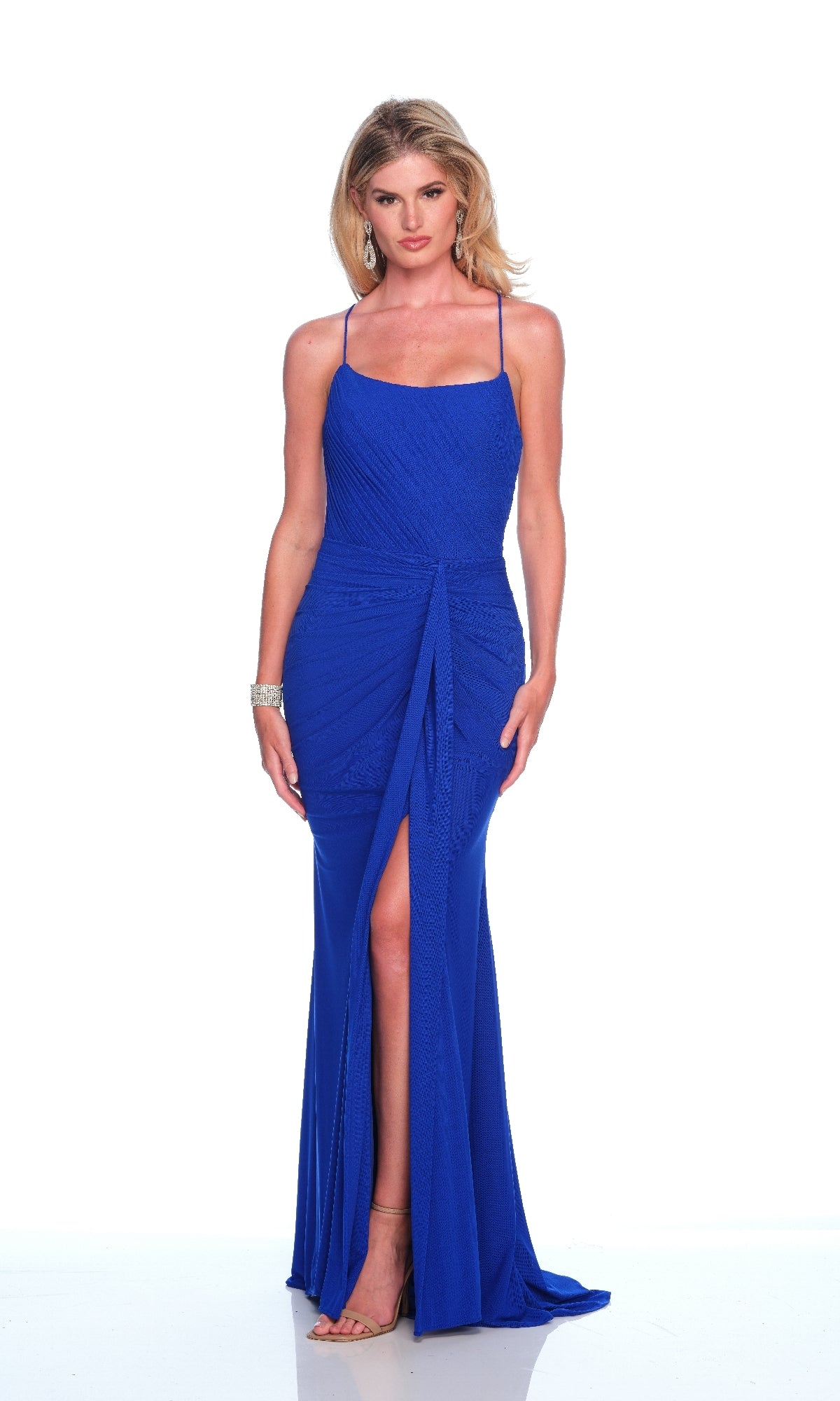 A woman faces forward wearing the Long Royal Prom Dress: Dave & Johnny 11954, featuring a scoop neckline and thigh-high slit, paired with silver jewelry and nude heels, set against a white background.